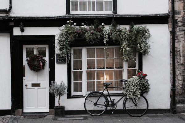 black city bike parked beside white and brown house during daytime