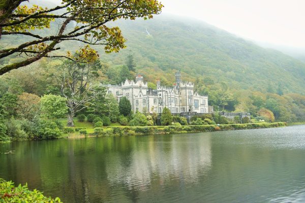 a large castle sitting on top of a lush green hillside