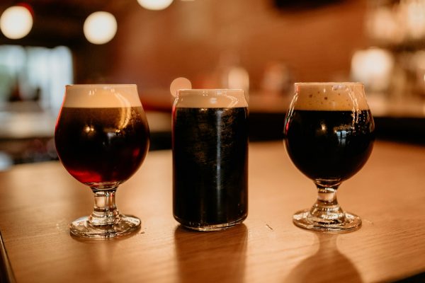 three different types of beer sitting on a table