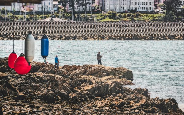 a group of people standing on top of a rocky shore